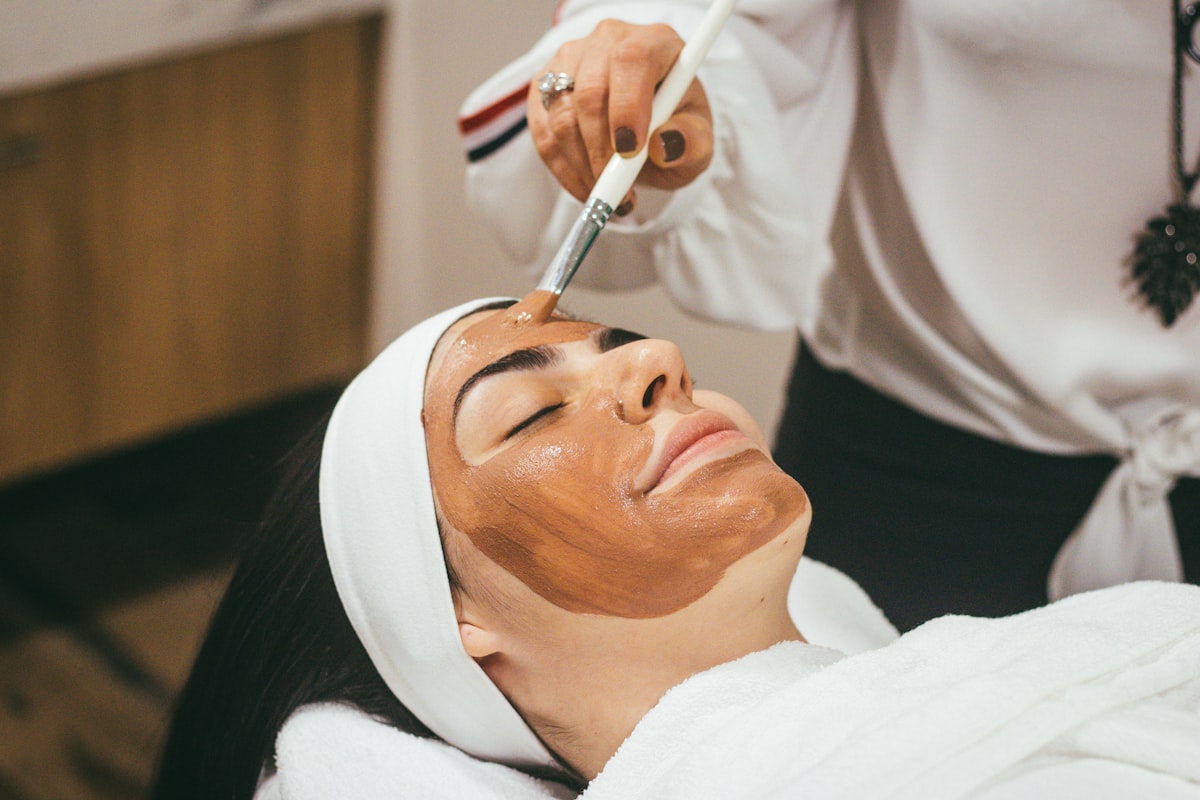 Client receiving a calming facial treatment by candlelight