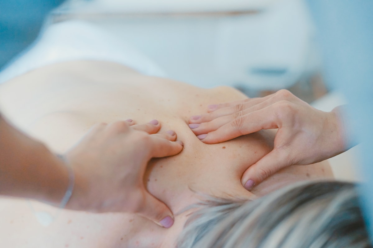 Deep tissue sports massage on a client’s upper back